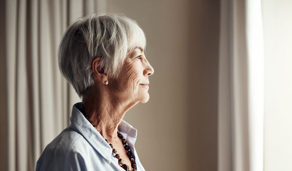 older woman looking out window