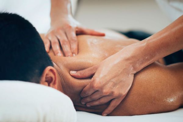 Man receiving massage to neck and shoulder