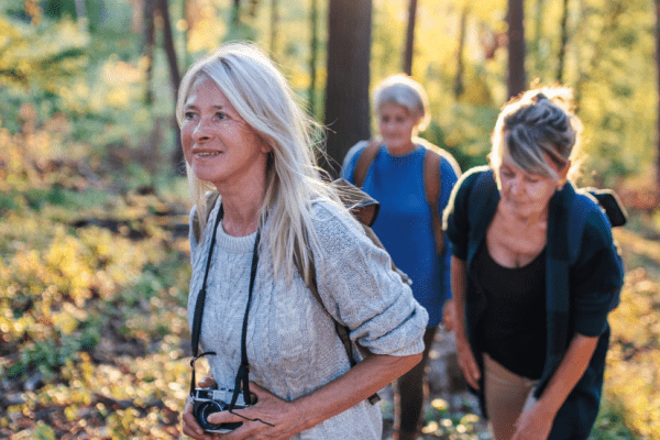 3 middle aged women hiking comfortably and happily