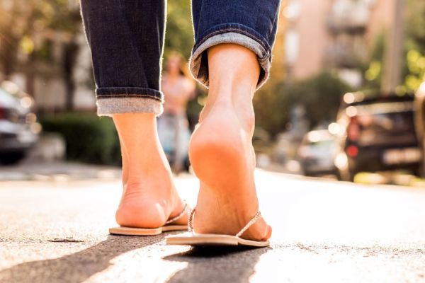 Woman's heel walking in open-back sandals 