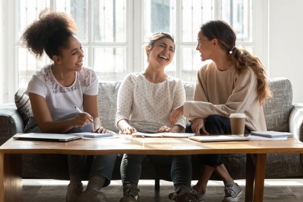 3 women laughing on couch