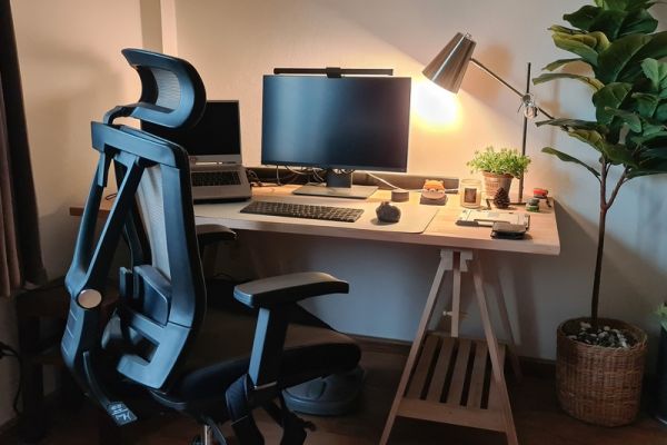 Ergonomic chair, table and monitor set up. With lamp and plant.