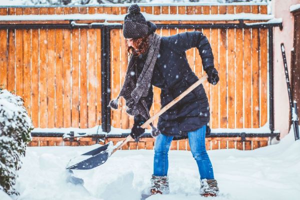 Woman shoveling snow off driveway