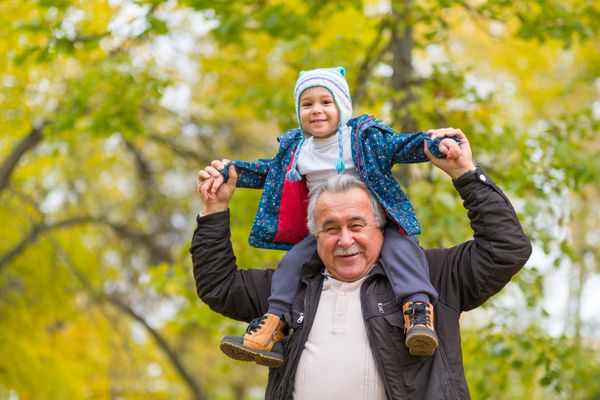 A grandfather and his grandson playing outside 