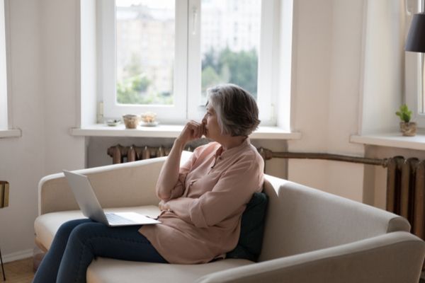 A pensive woman sitting at home 