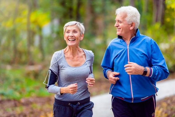 an older couple running outdoors in spring 