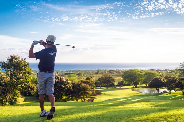 A man swinging his golf club on a course