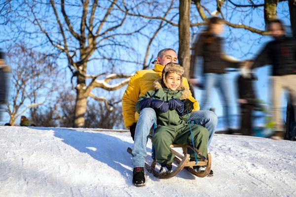 a father and son going tobogganing 