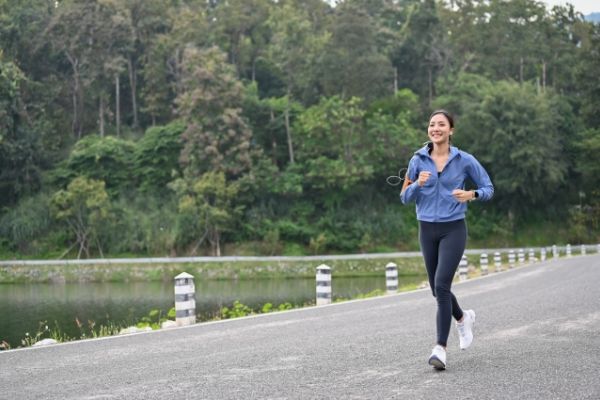 Female fitness runner getting ready for jogging outdoors.