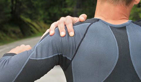 man with a shoulder injury while exercising outdoors