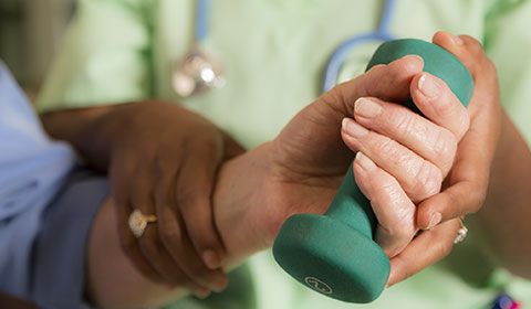 Therapist working with a patient on hand exercises