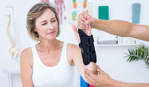 woman at physiotherapist with wrist brace