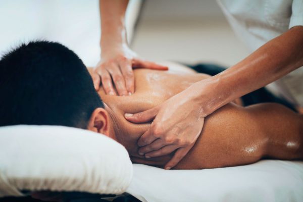 Man receiving massage to neck and shoulder