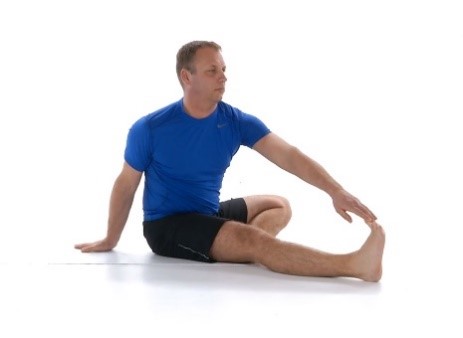 A man doing  a seated hamstring stretch