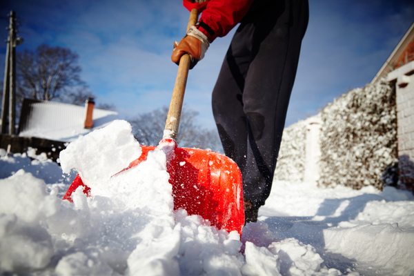 a man shovelling snow in the winter