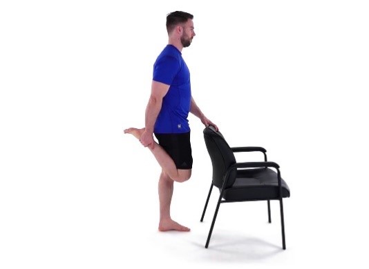 A man doing a standing quad stretch