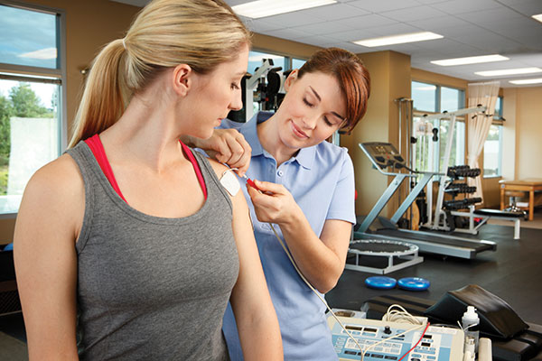 woman working with a physiotherapist on her shoulder